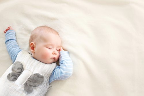 A newborn using the Snuggy Buddy.