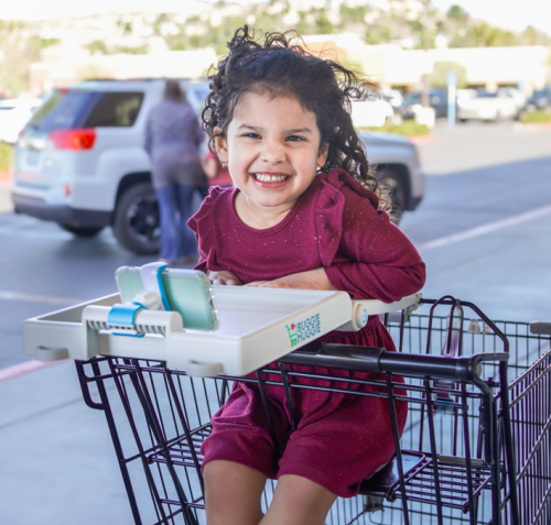 A child using the Buggie Huggie Shopping Cart Tray.