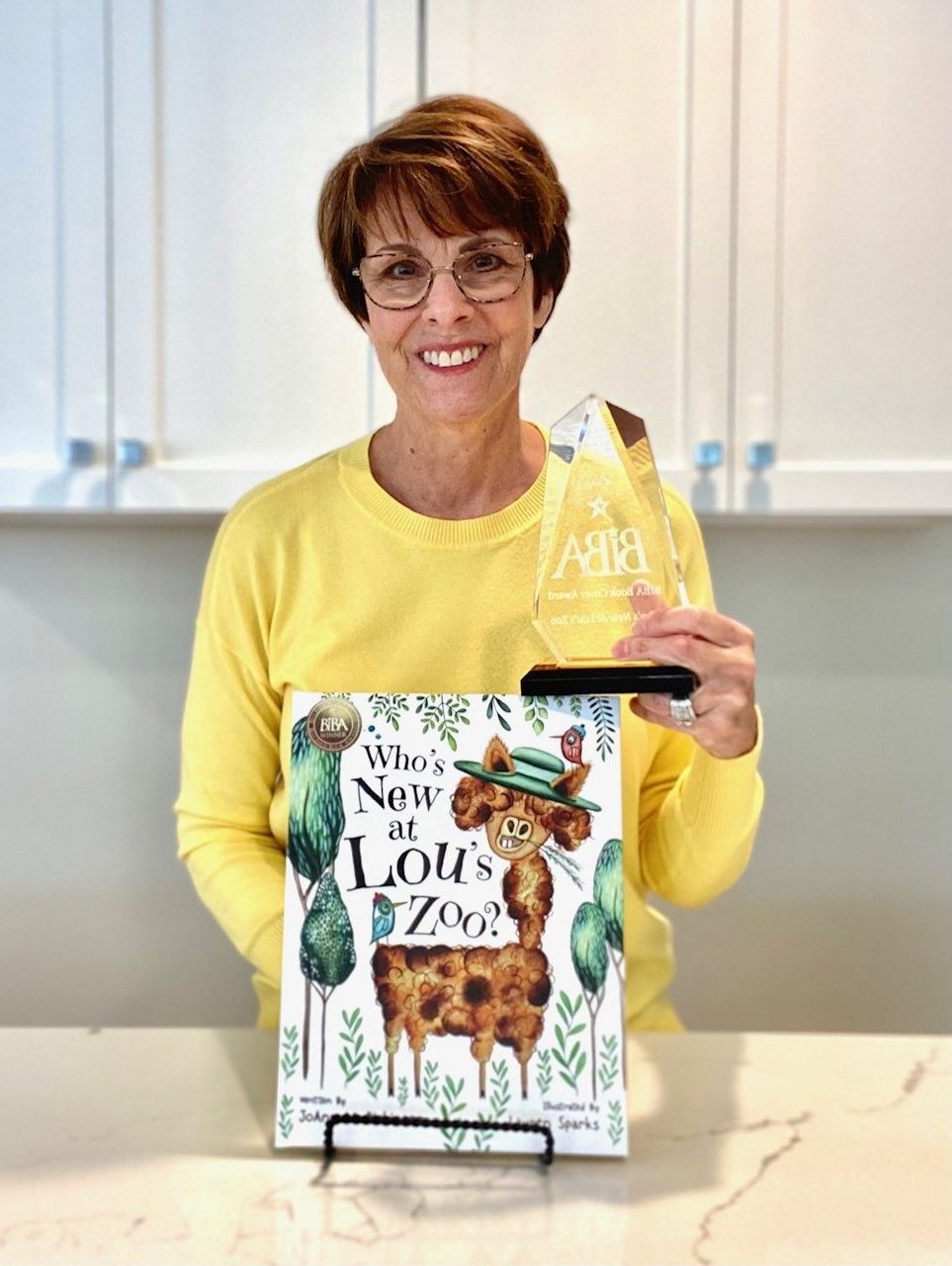 JoAnn Dickinson with her "Best Indie Book Award" for "Who's New At Lou's Zoo."